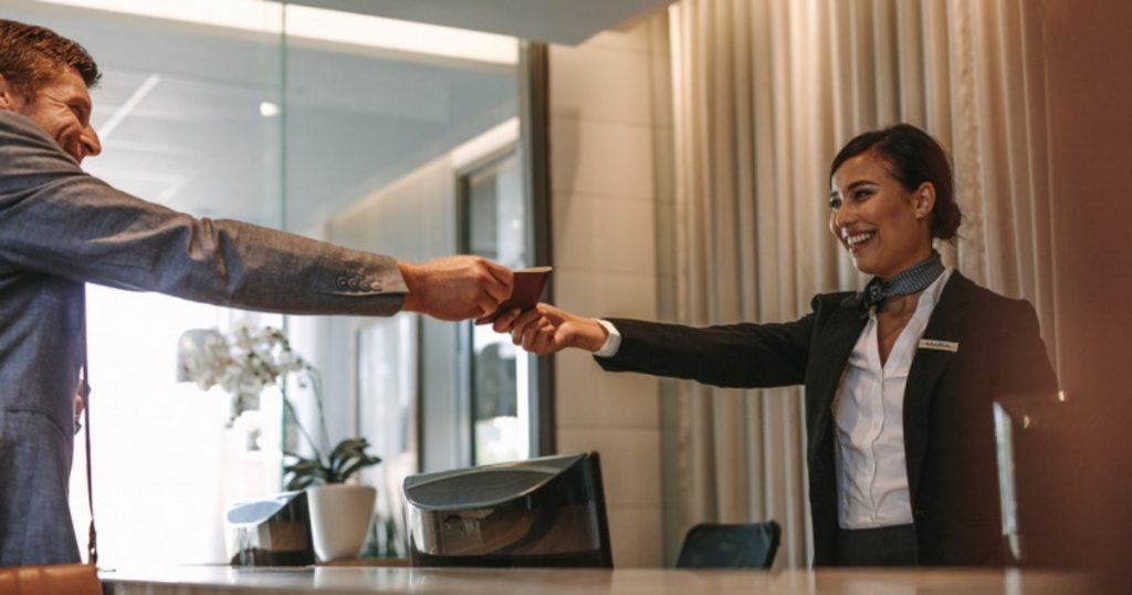 Hotel concierge welcoming a guest at a reception desk